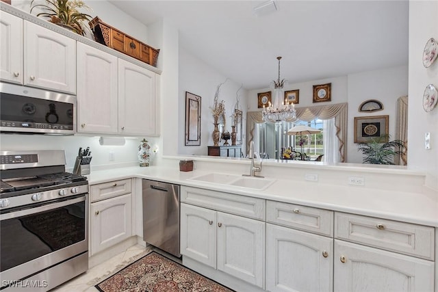 8469 Mallards Way, Naples, FL 34114 - kitchen featuring appliances with stainless steel finishes, a sink, a chandelier, and light countertops