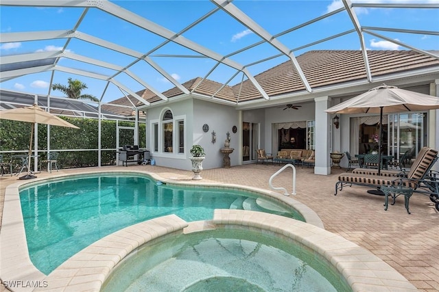 view of swimming pool featuring an in ground hot tub, a lanai, ceiling fan, and a patio