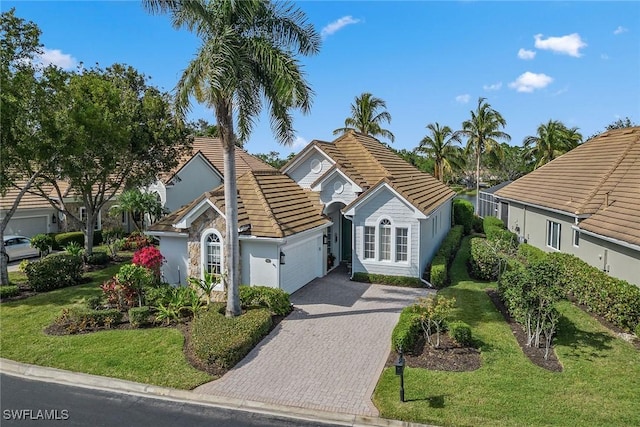 8469 Mallards Way, Naples, FL 34114 - view of front facade with a tile roof, an attached garage, driveway, stucco siding, and a front yard