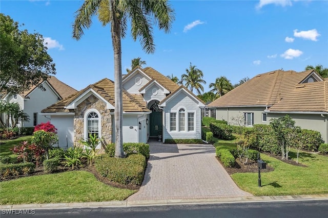 8469 Mallards Way, Naples, FL 34114 - ranch-style home featuring a tile roof, an attached garage, decorative driveway, and a front lawn
