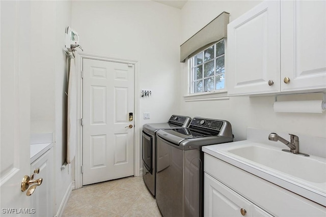 laundry area featuring cabinets, sink, light tile patterned floors, and independent washer and dryer