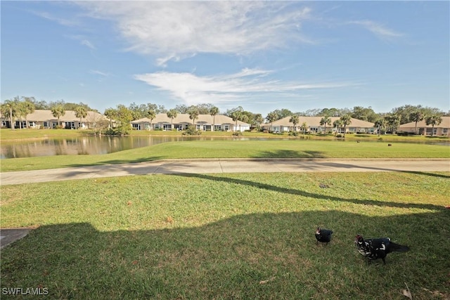 surrounding community featuring a water view and a lawn