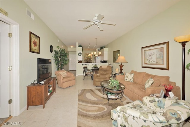 living room with ceiling fan with notable chandelier, vaulted ceiling, and light tile patterned floors