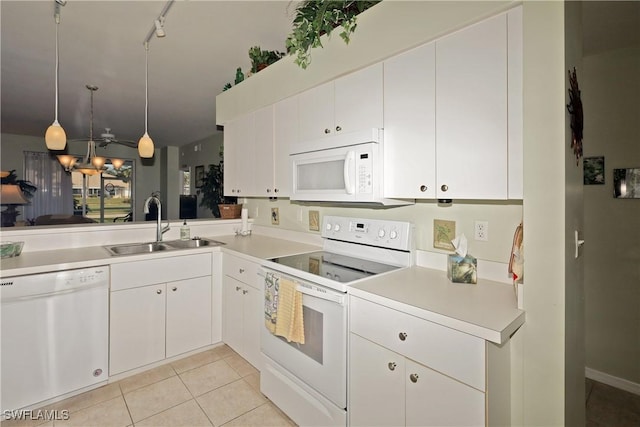 kitchen with sink, decorative light fixtures, light tile patterned floors, white appliances, and white cabinets