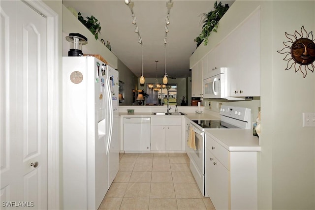 kitchen featuring sink, white cabinets, light tile patterned floors, track lighting, and white appliances