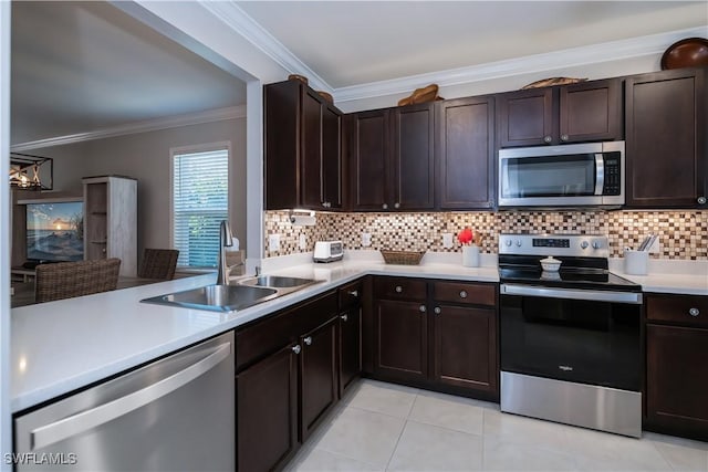 kitchen with sink, crown molding, light tile patterned floors, appliances with stainless steel finishes, and decorative backsplash