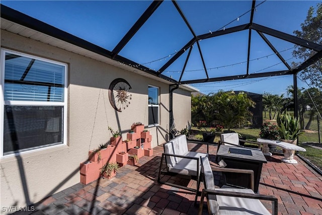 view of patio / terrace with a fire pit and glass enclosure