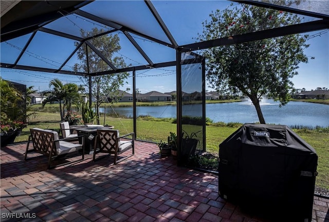 view of patio / terrace with a water view, a grill, and glass enclosure