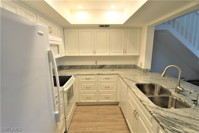 kitchen with white cabinetry, sink, white appliances, and a tray ceiling