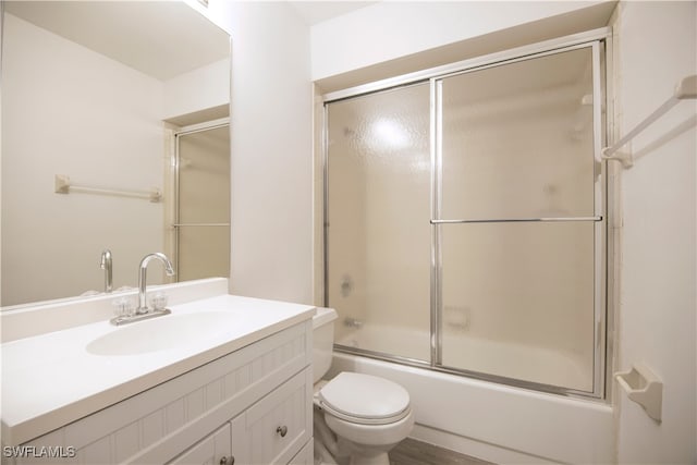 full bathroom featuring toilet, vanity, and bath / shower combo with glass door