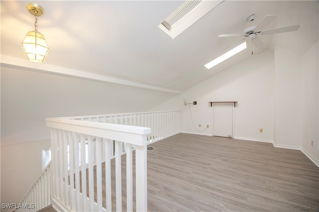 additional living space featuring ceiling fan, wood-type flooring, and vaulted ceiling with skylight