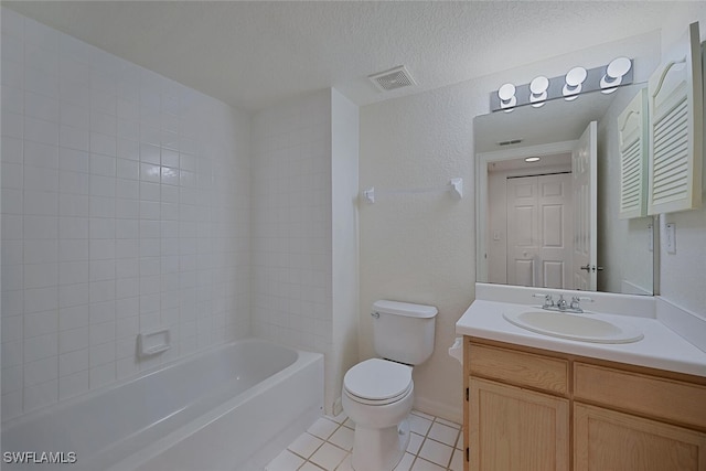 full bathroom with tiled shower / bath, tile patterned flooring, vanity, toilet, and a textured ceiling