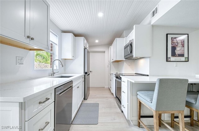 kitchen featuring stainless steel appliances, sink, and white cabinets