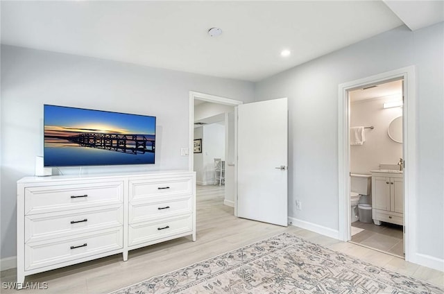 unfurnished bedroom featuring sink, ensuite bath, and light hardwood / wood-style flooring