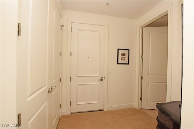 hallway featuring light colored carpet