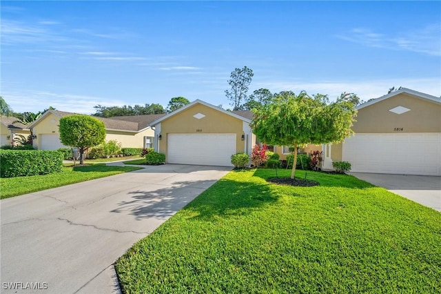 single story home featuring driveway, a garage, a front yard, and stucco siding