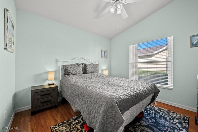 bedroom featuring a ceiling fan, vaulted ceiling, baseboards, and wood finished floors