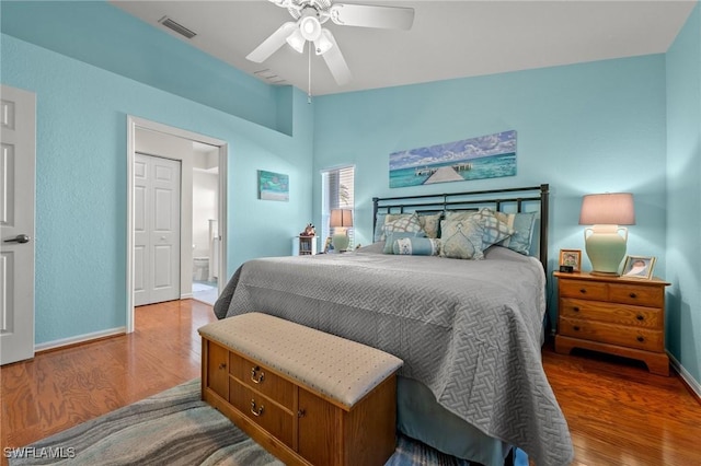 bedroom with baseboards, visible vents, a ceiling fan, lofted ceiling, and wood finished floors