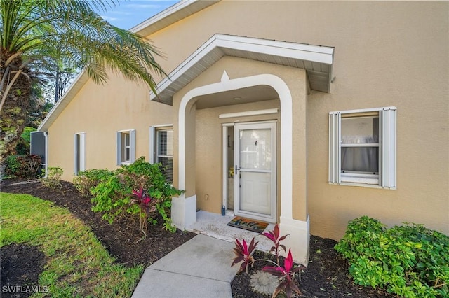 entrance to property featuring stucco siding