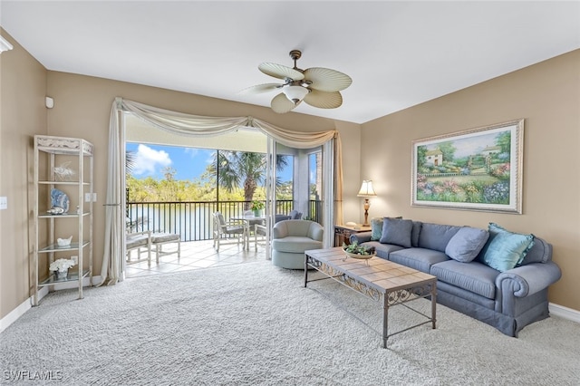 living room featuring a water view, ceiling fan, and carpet