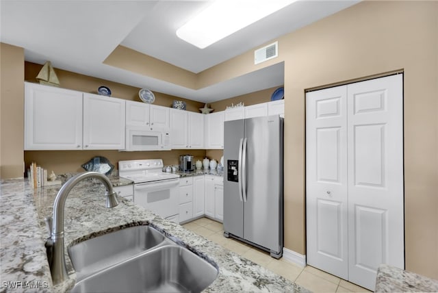 kitchen with white cabinetry, sink, light stone counters, and white appliances