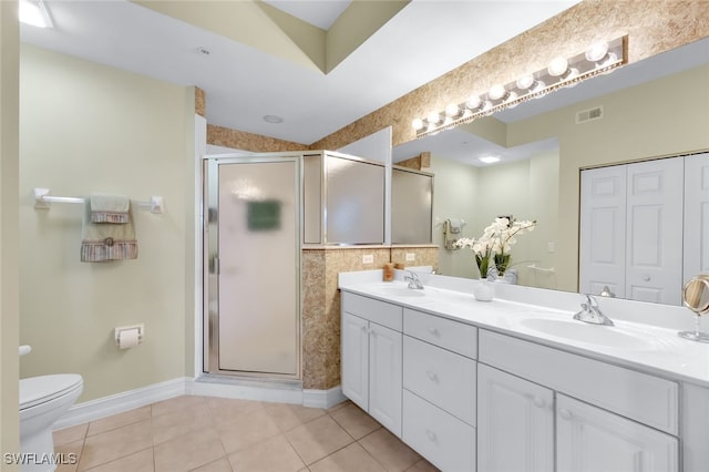 bathroom with vanity, toilet, a shower with shower door, and tile patterned flooring