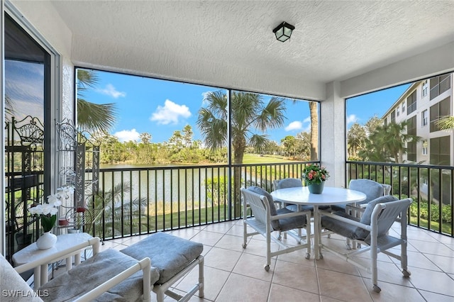 sunroom / solarium featuring a water view