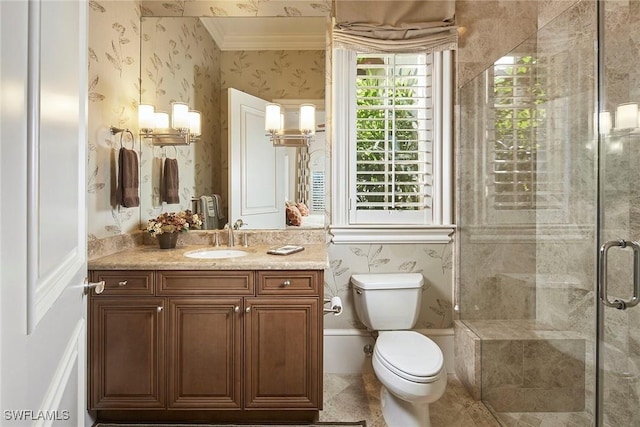 bathroom with crown molding, vanity, toilet, and a shower with door