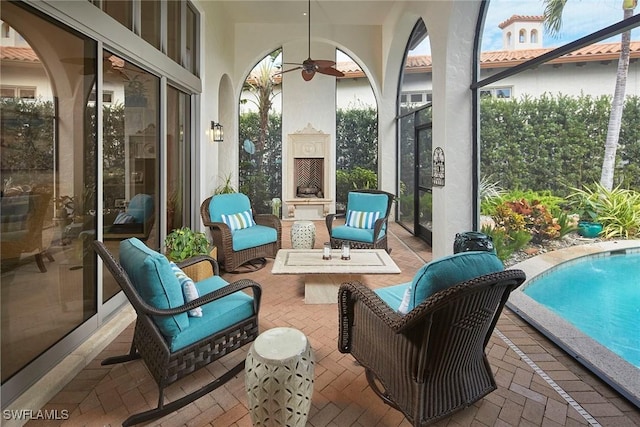 view of patio / terrace featuring ceiling fan and a fireplace