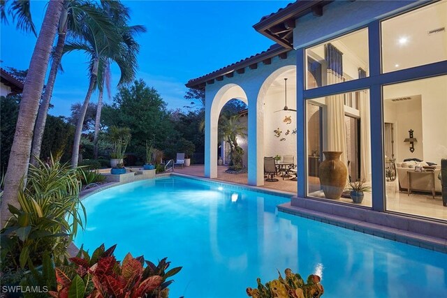 pool at dusk featuring a patio area