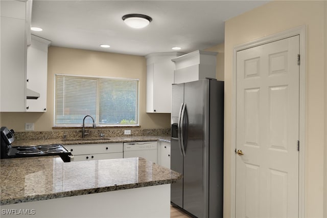 kitchen with white cabinets, stainless steel fridge, electric range, white dishwasher, and kitchen peninsula