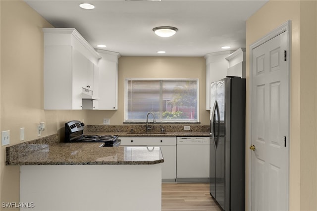 kitchen with stainless steel appliances, kitchen peninsula, sink, and white cabinets