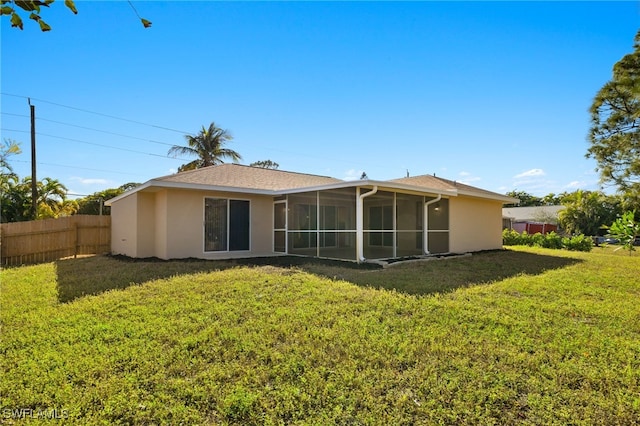 back of property with a sunroom and a lawn