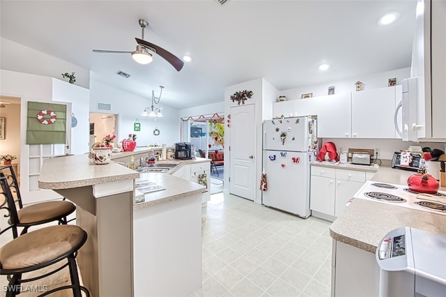 kitchen with sink, white appliances, a breakfast bar area, white cabinetry, and an island with sink