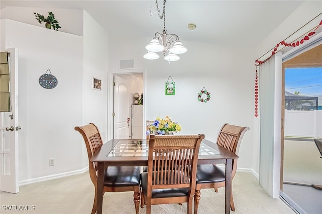 dining area with lofted ceiling, light carpet, and a notable chandelier