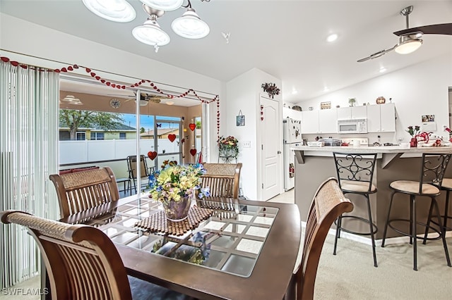 dining room with lofted ceiling, light carpet, and ceiling fan