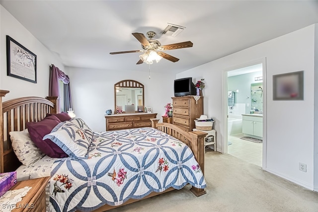 carpeted bedroom with ceiling fan and ensuite bath