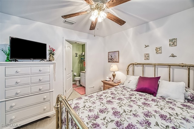 bedroom featuring light carpet, ceiling fan, and ensuite bathroom