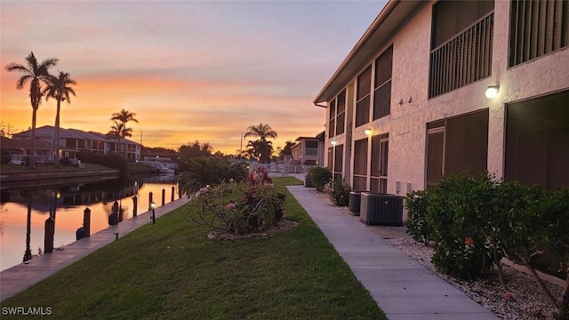 view of home's community featuring a lawn and a water view