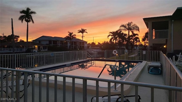 pool at dusk with a patio