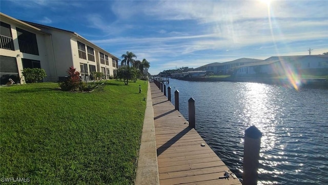 view of dock featuring a water view and a lawn