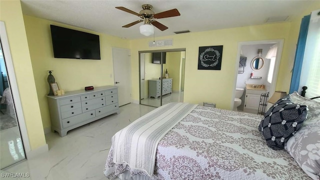 bedroom with ceiling fan, ensuite bath, and a closet