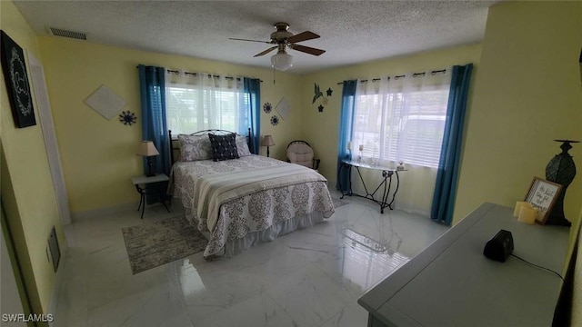 bedroom with multiple windows, a textured ceiling, and ceiling fan