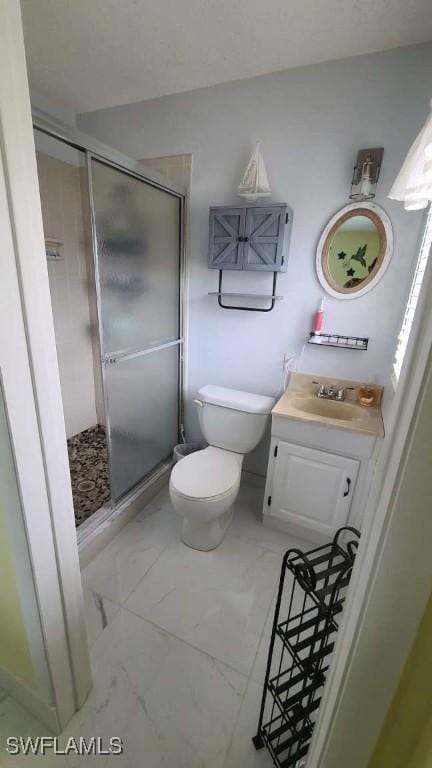 bathroom featuring vanity, toilet, and an enclosed shower