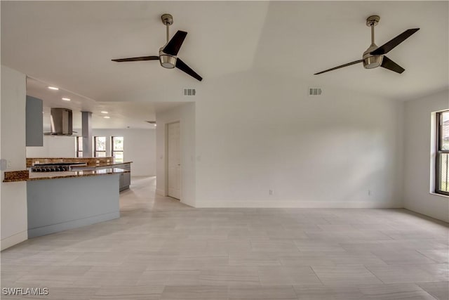 unfurnished living room with vaulted ceiling, ceiling fan, and light tile patterned flooring