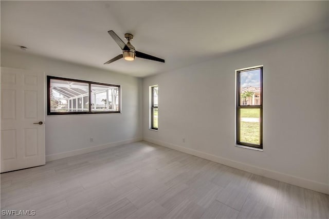 unfurnished room featuring a wealth of natural light and ceiling fan