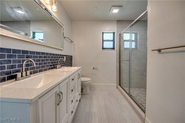 bathroom with tasteful backsplash, vanity, toilet, and an enclosed shower