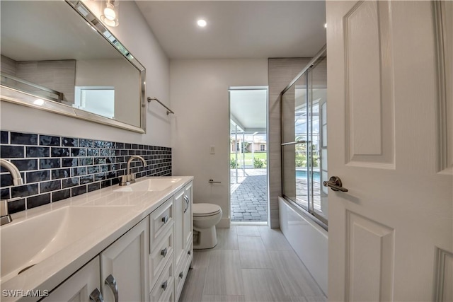 full bathroom featuring vanity, combined bath / shower with glass door, tile patterned floors, and toilet