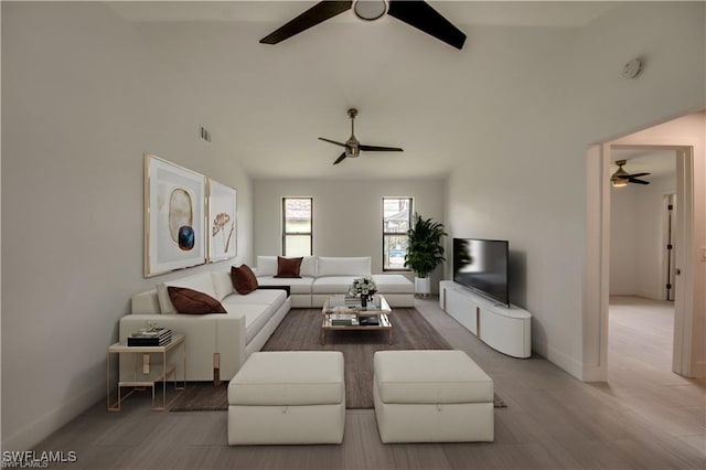 living room featuring hardwood / wood-style flooring, lofted ceiling, and ceiling fan