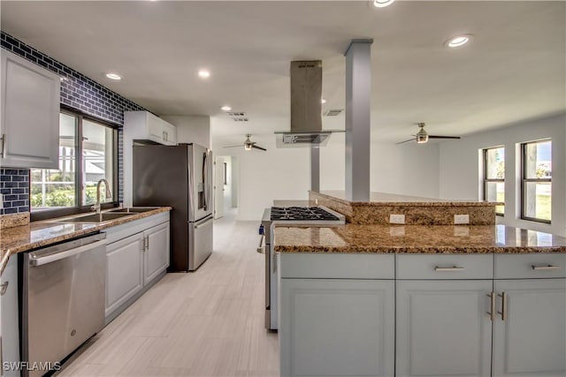 kitchen featuring sink, appliances with stainless steel finishes, light stone counters, white cabinets, and island exhaust hood